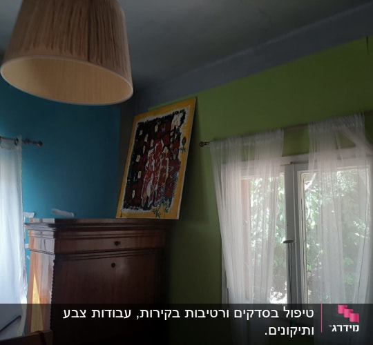 חדר עם קירות צבועים בצבעים שונים, וילונות תלויים